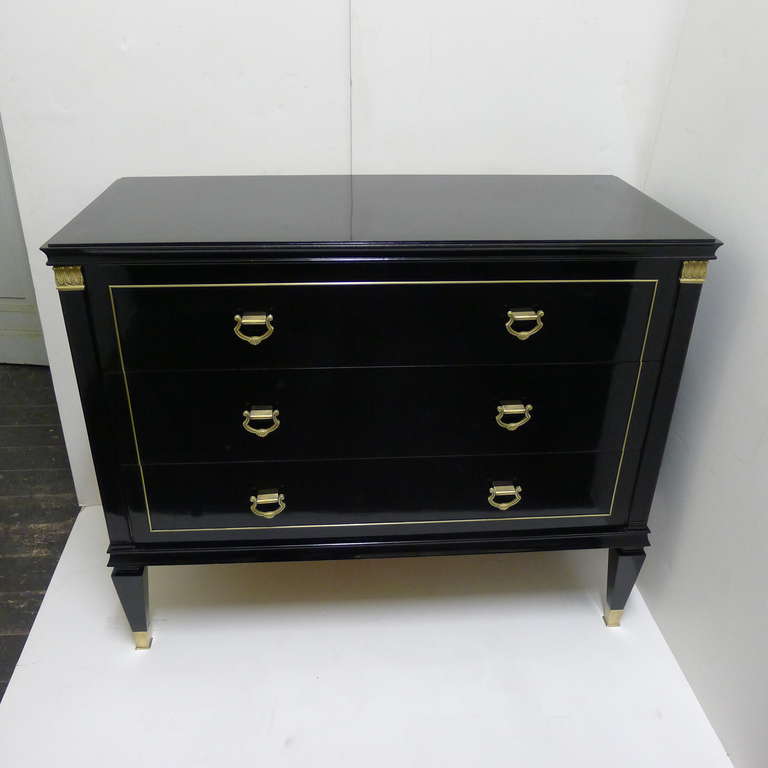 a black ebonized chest with bronze details.