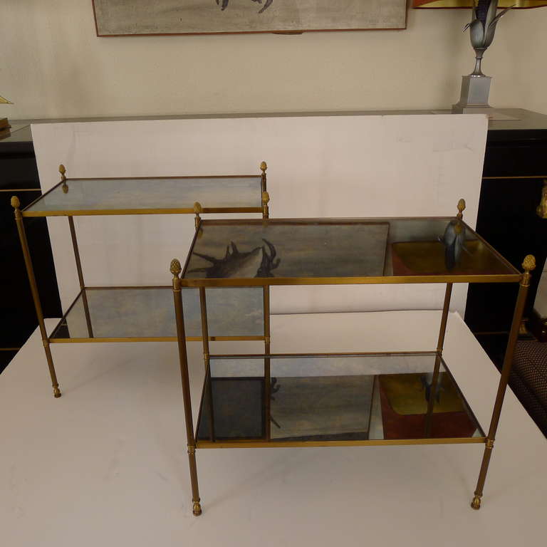 A pair of two tier side tables in bronze with patined mirror tabletop.