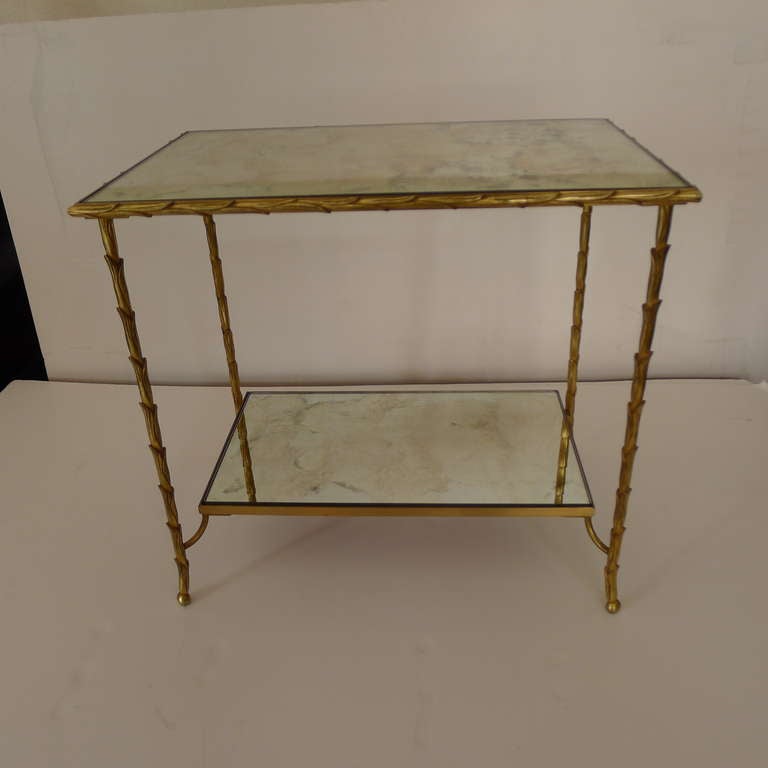 A two tier coffee table in bronze with patined mirror tabletop