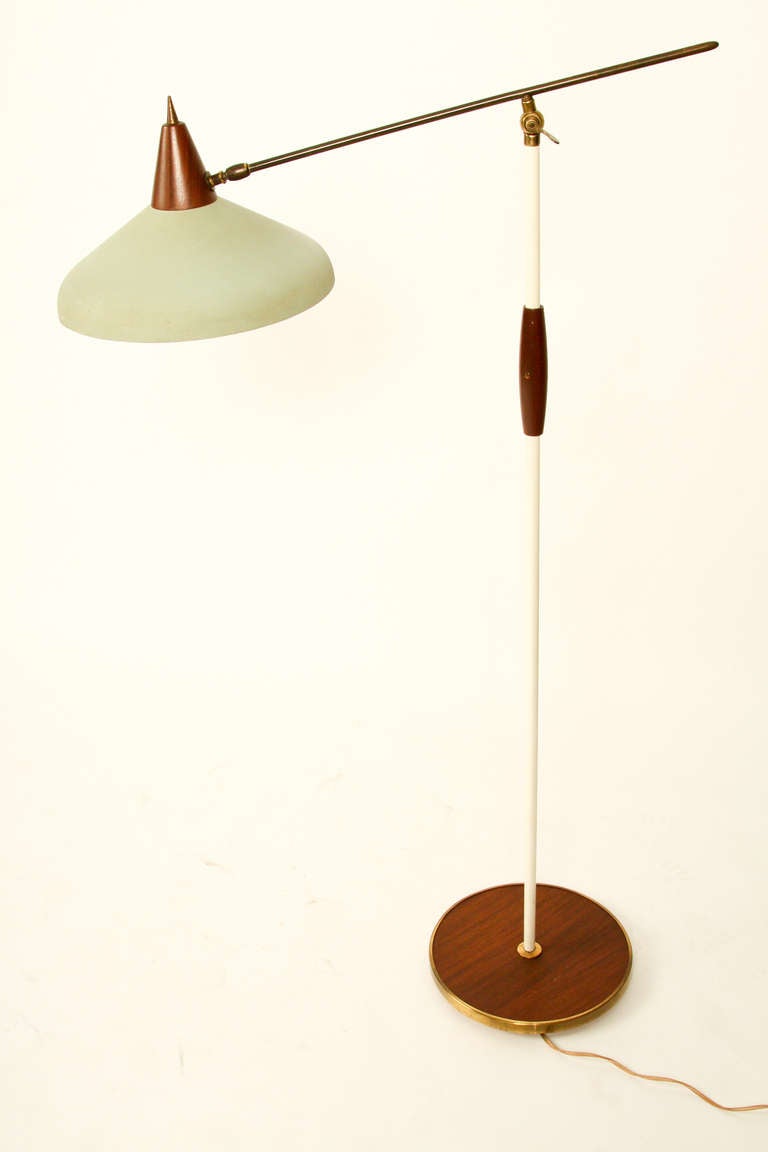 Floorlamp with a rare hat. The hat is of metal, and the top is of teakwood. The top-top is of brass. Also the horizontal line is of massive brass. The base is of wood with an edge of brass.