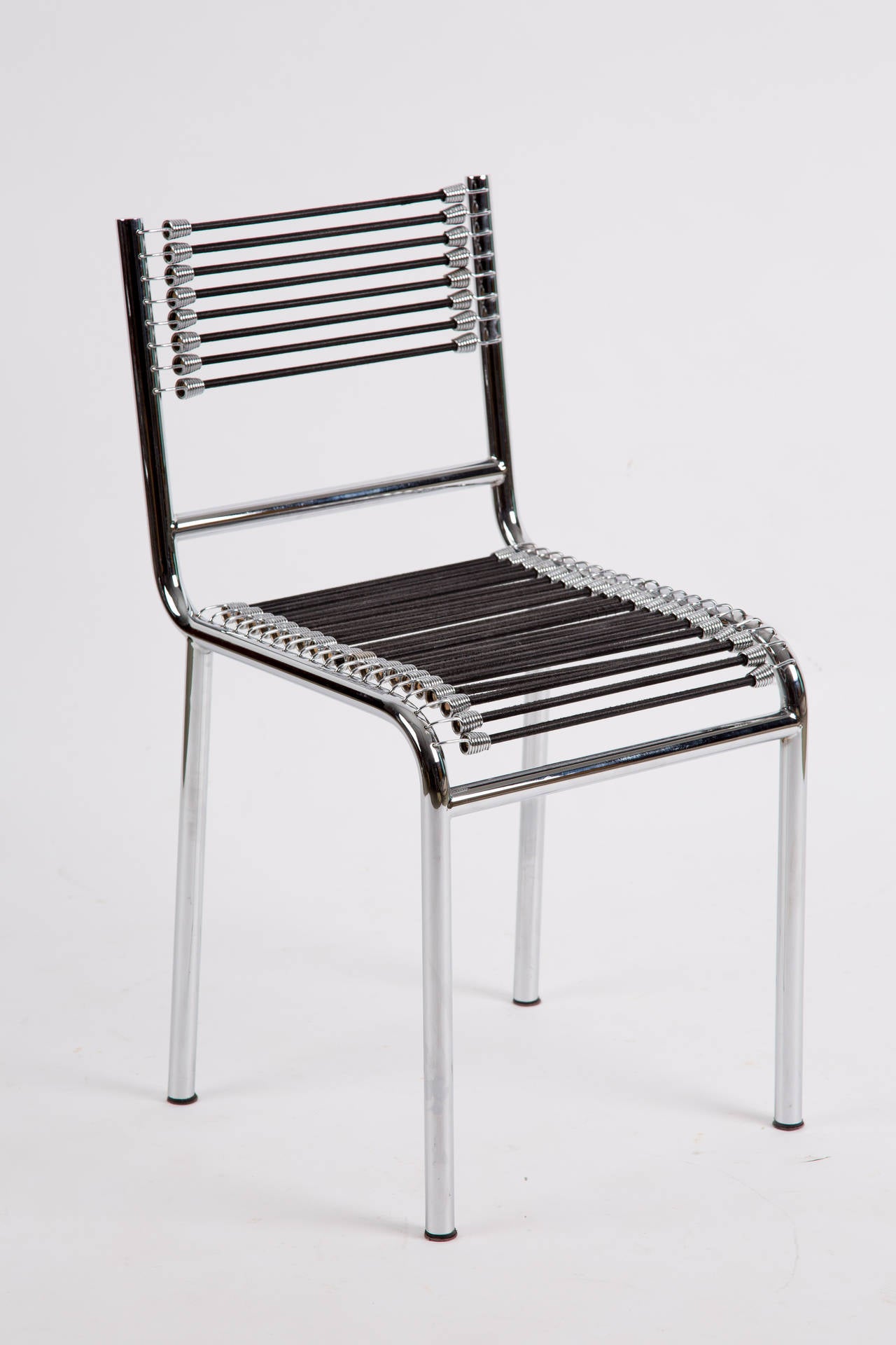 A set of four chrome plated chairs from 1989. The sitting and back are of elastic bands with fabric.