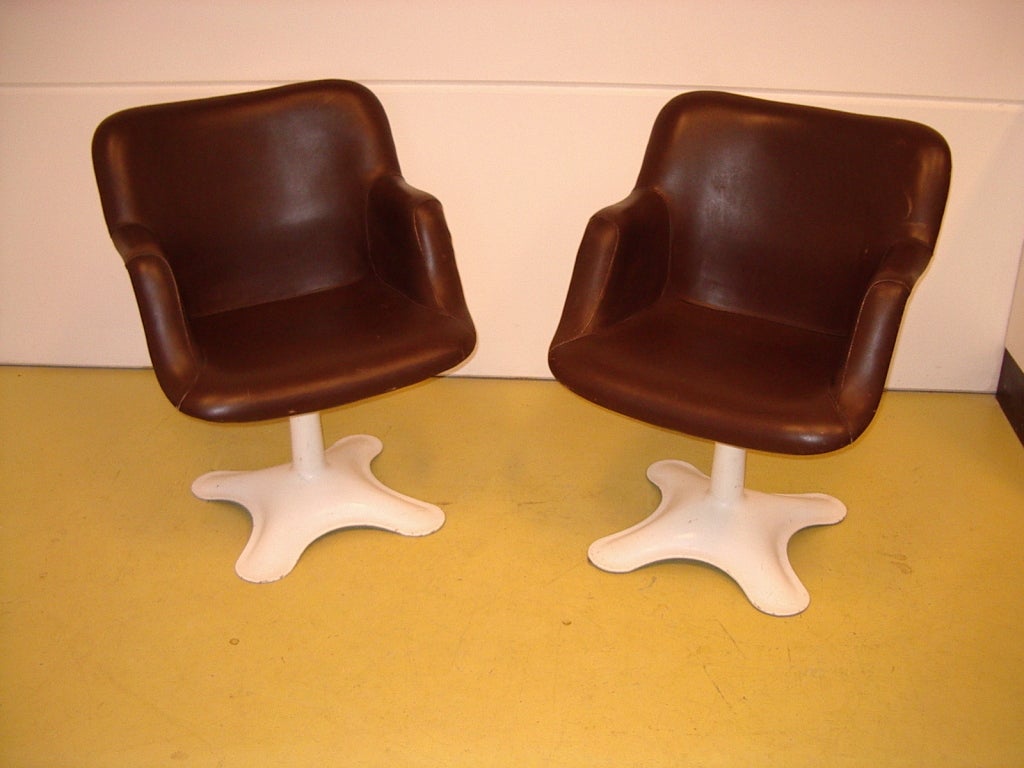 A set of Finnish Kukkapuro. Two chairs and one table. The sitting of the chairs is of leather. The table has filled with sand for its weight. Materials and techniques notes: Metal base and brown leather sitting. The chairs are of polyester and can