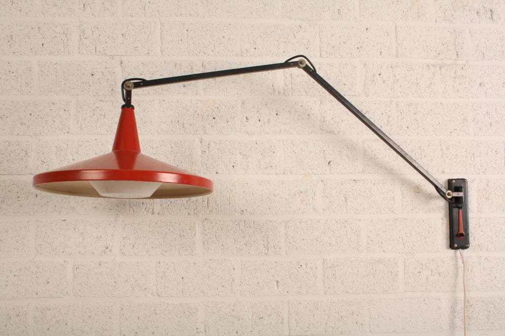 Panama lamp with red aluminium hat. This lamp has been designed by W.Rietveld for Gispen. It has a very rare elbow construction to fix the lamp.Therefore you need a red key, placed unther the switch!

Diameter hat is 40 cm, height is 29 cm, lenght
