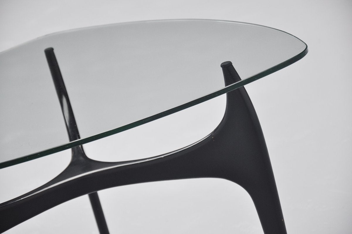 Fantastic subtle coffee table from the Luxus series designed by Jos De Mey for Van den Berghe Pauvers, Belgium, 1957. This rare table has a typical Belgian shaped solid wooden base, black lacquered. Rubber protections between the glass and the base.
