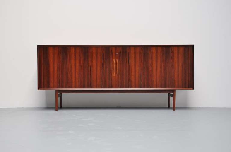 Very nice sideboard by Arne Vodder for Sibast Mobler, Denmark 1960. This sideboard has tambour doors and several shelves and drawers on the inside. The sideboard is fully restored and in fantastic condition again. Super grained rosewood looks