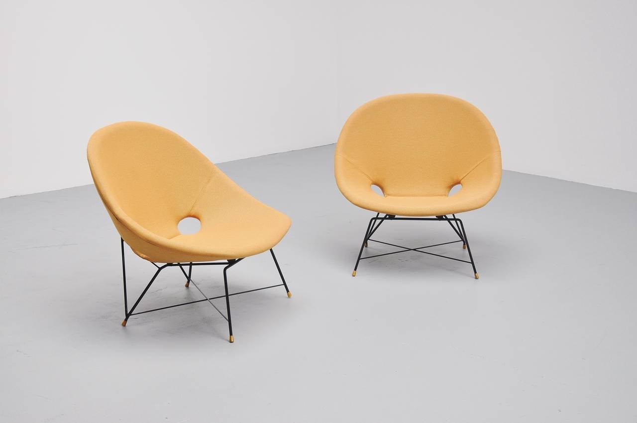 Spectacular pair of lounge chairs designed by Augusto Bozzi for Saporiti Italia, Italy 1954. These chairs have a black lacquered metal frame with solid brass feet. The chairs still have its original upholstery in very good condition. High quality