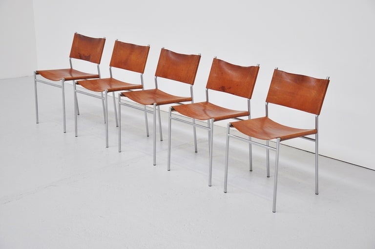 Here for a fantastic set of 5 dining chairs designed by Martin Visser for 't Spectrum, 1967. These chairs have a fantastic patina on the cognac leather and look great because of that. They have a brushed steel frame and seat excellent!