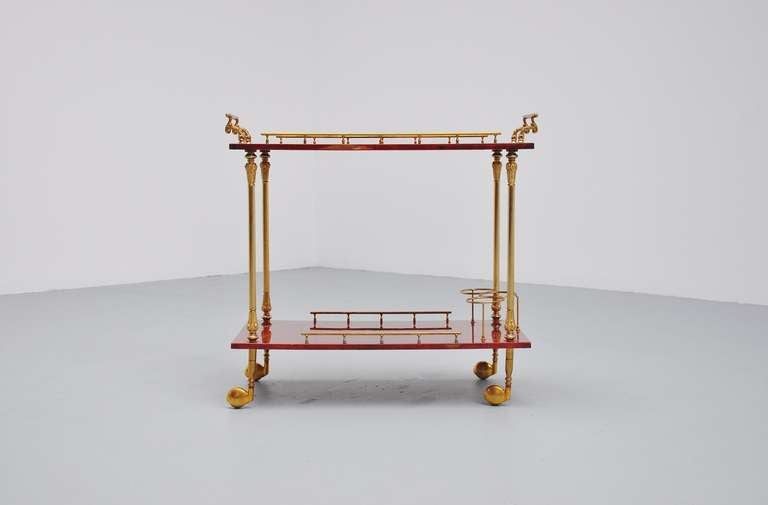 2 Tier red goat skin covered serving cart, with brass gallery edge and handles, carved arced pull handles and wheel posts, This is designed by Aldo Tura for Tura Milano ca 1960. Cart is in original condition and marked with original sticker on the