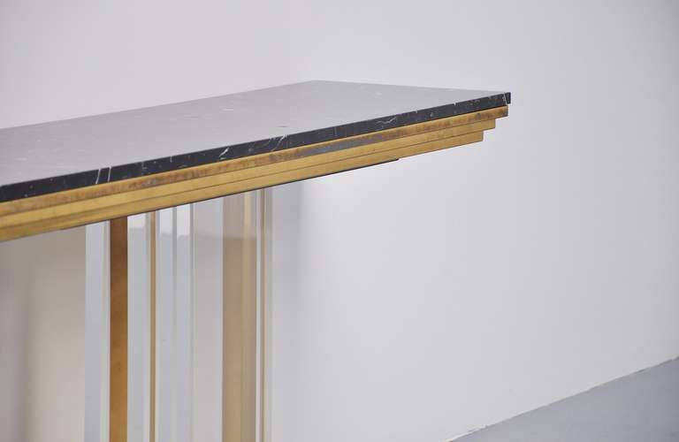 Fantastic console table by Romeo Rega, Italy 1970. This superb console table has a high quality lucite and brass base. Fantastic shaped and a black carrera marble top. The tabls would be a centerpiece of attention when coming into your home or