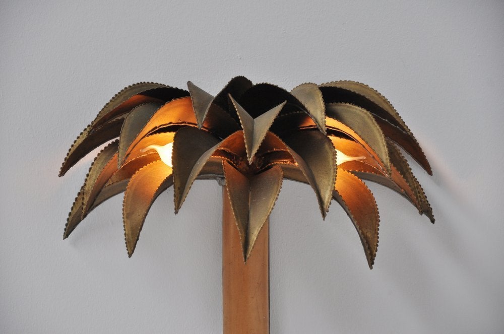 Highly decorative brass palmtree wall lamp. The lamp uses 2 light bubls covered by leaves that gives fantastic warm light when lit. Super cool and nice sized wall lamp in good complete condition.