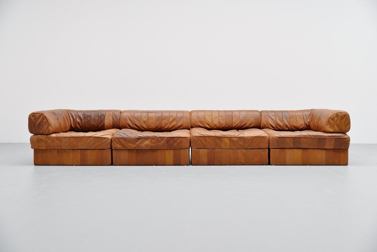 Fantastic leather patchwork sofa designed by De Sede team, Switzerland 1970. This camel leather patchwork sofa looks amazing with all the patches in leather. This is a 4 elemented sofa with a small table in the middle which can also be used as a