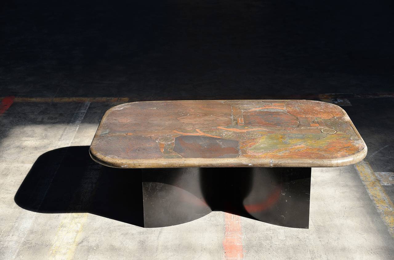Very nice sober and early example of a Paul Kingma coffee table. Made of molded concrete with slate, stone and brass inlay. The top rests on two C-shaped black lacquered metal pases and is very stabile.

Paul Kingma was well known for his