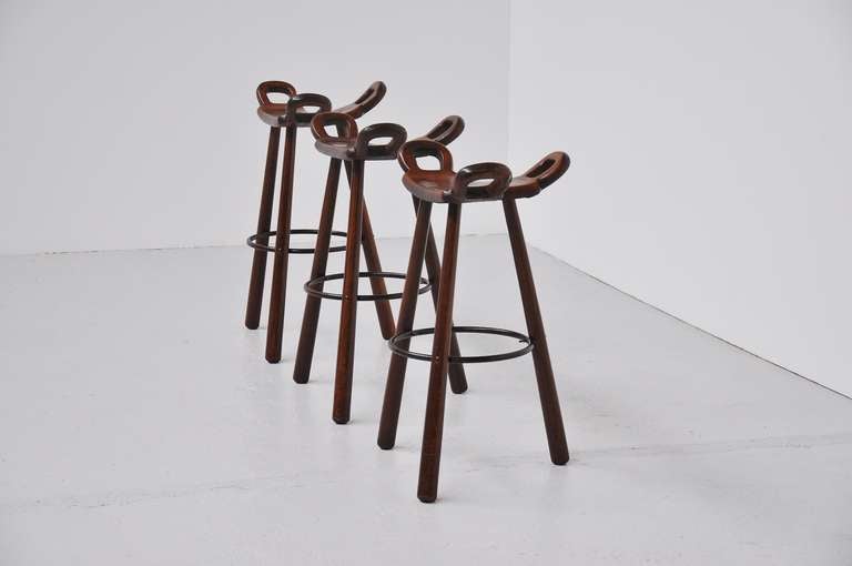 Very nice set of 3 bar stools, made in Spain 1950. These fantastic made stools are made of solid oak wood, dark stained, with very nice looking dovetail connections and details. The feet supports are made of metal, very nice made stools in authentic