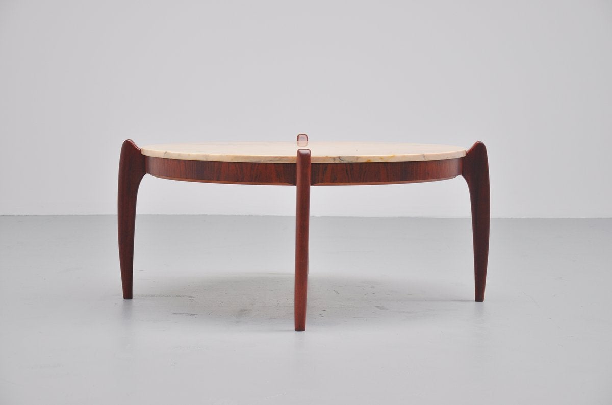 Very nice and rare coffee table by Percival Lafer, Brazil, 1960. This round coffee table is made of jacaranda rosewood and it has an off white and reddish glazed marble top. The coffee table has a very nice and organic shape and has the paper