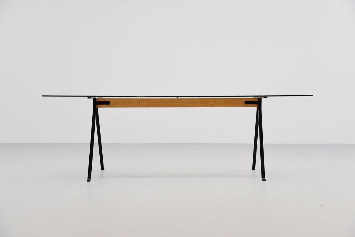 Very nice and early dining table designed by Enzo Mari for Driade Italy 1973. This table was purchased mid-1970s and has a nice patina from age to it. It has a wooden support with black lacquered solid metal legs to support the long glass top. Glass