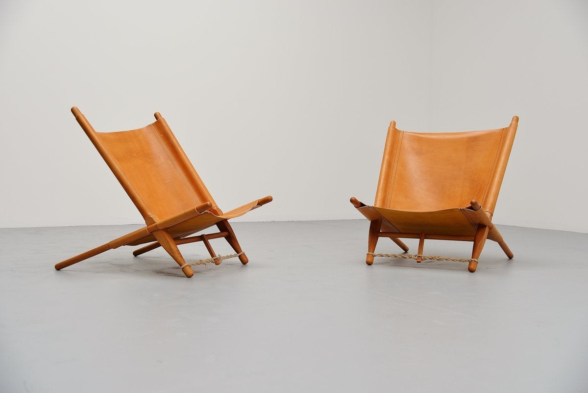 Very nice pair of lounge chairs designed by Ole Gjerløv-Knudsen for Cado, Denmark 1958. These chairs have solid birch frames and thick saddle leather seats with nice patina. The chairs look amazing in a matching pair and are adjustable in seating