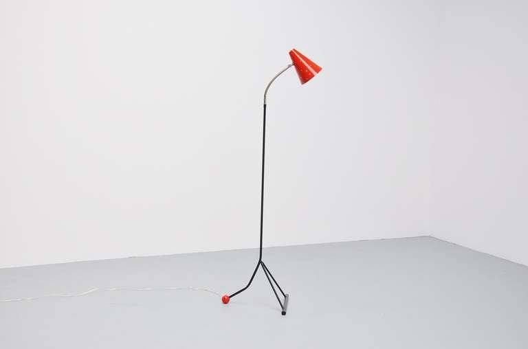 Very nice large floor lamp made by Hala, Holland, circa 1960. This lamp has a very nice triangle shade and a red lacquered ball end. The lamp has a flexible arm to adjust the lamp in different positions. The shade has a die cut pattern all over for