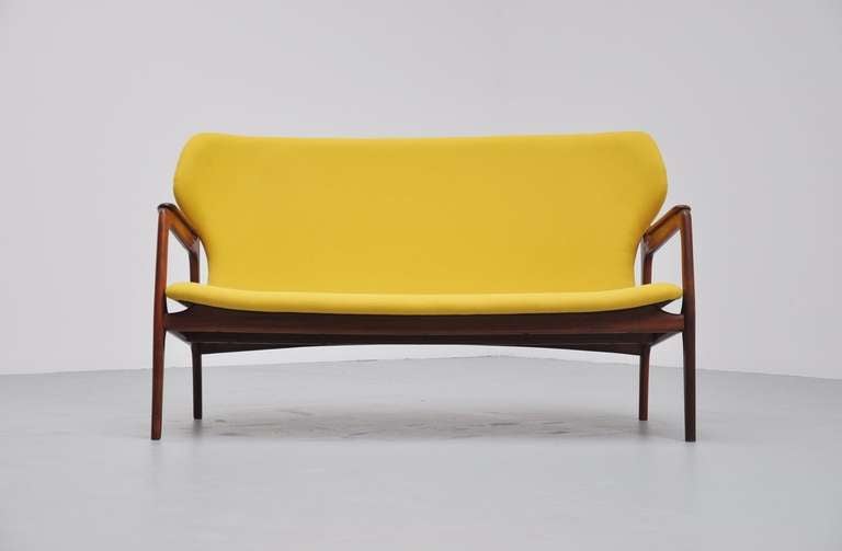 Very nice shaped lounge sofa made in Denmark 1960. Unknown manufacturer or maker, solid teak frame with newly upholstered yellow seat. Have a look at the very nice detailed dovetail connection at the sides. Comfortable 2 seater sofa, looking great