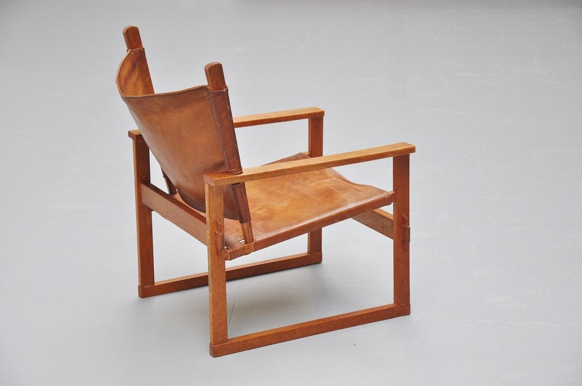 Nicely made Safari chair designed by Poul Hundevad for Vamdrup, Denmark 1950. This chair was made of solid oak and has its original natural leather seat and back. Very nice patina to the leather and in good condition. The chair comes fully a part
