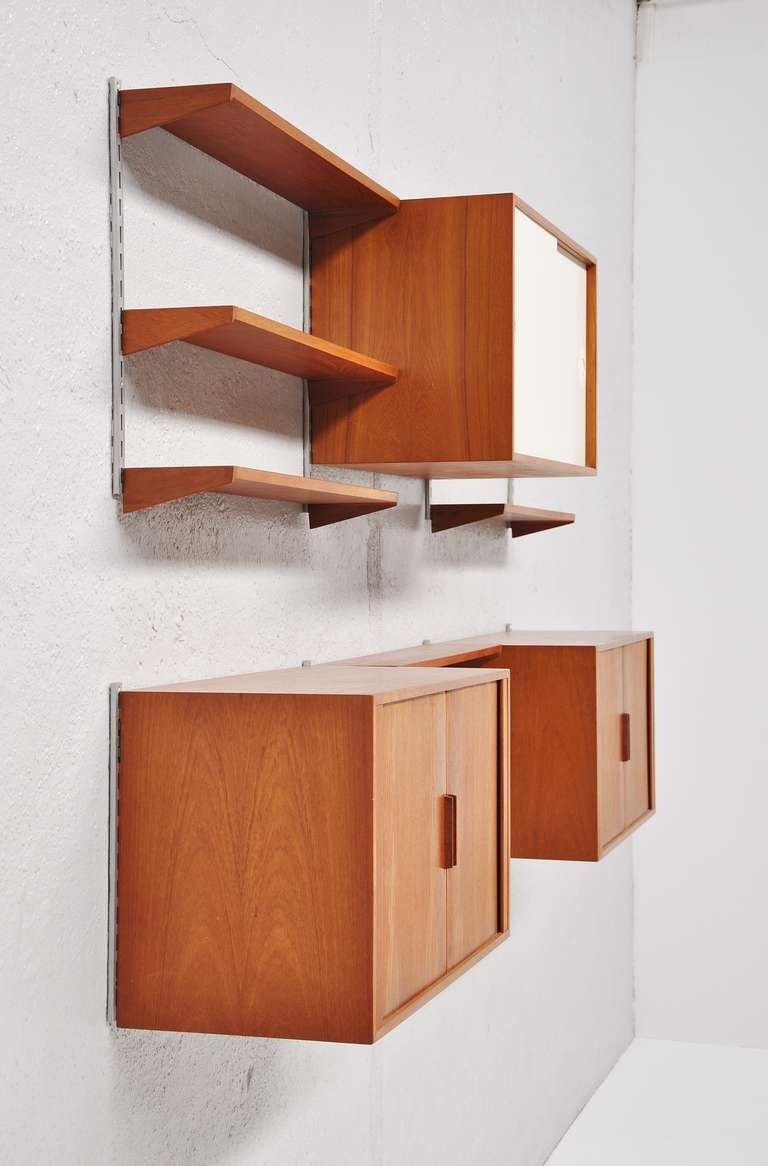 Fantastic shaped high quality Danish shelving system. Designed by Kai Kristiansen for FM Mobler, Denmark, 1960. Very nice wall unit with several shelves for storage, two cabinets with tambourin doors and one cabinet with white sliding doors. In
