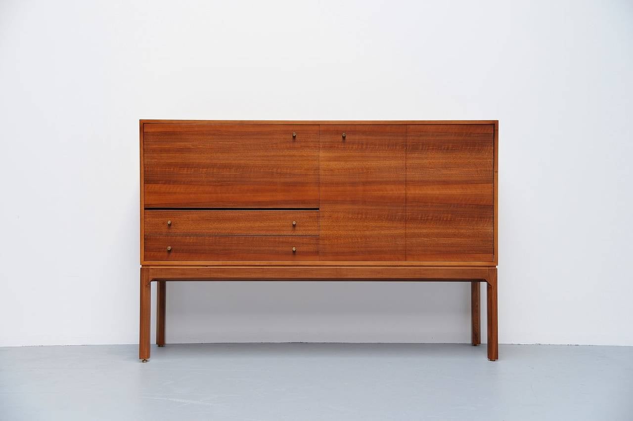 Here for a very nice large cabinet designed by Jos De Mey for Van den Berghe-Pauvers, Belgium, 1960. This cabinet is from the Abstrakta series from Jos De Mey and this is a very early 1960s example in walnut veneer. It has brass handles and details,