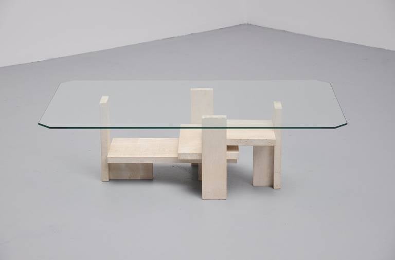 Very nice sculptural coffee table designed and made by Studio Willy Ballez, Belgium 1970. This table has a solid travertine base and a square glass top with edged corners. The table has a very nice modernist shaped base and is in excellent