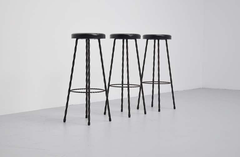Very nice set of three (possible six) French wrought iron bar stools. These stools have twisted solid iron frames and have black vinyl (original) upholstery. Very nice and decorative set of stools. Six available in total, priced per three.

Please