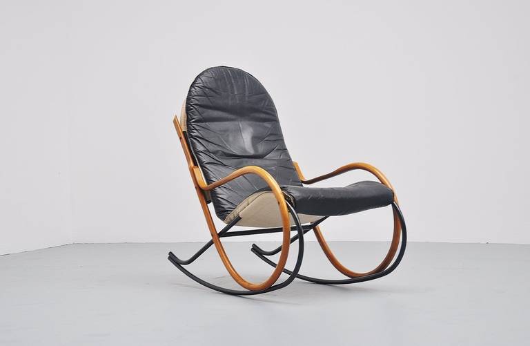 Very nice sculptural rocking chair designed by Paul Tuttle for Strässle International, Switzerland, 1972. The base is made of a black lacquered tubular frame and has plywood arm rests. A leather seat with canvas back is a great contrast with the