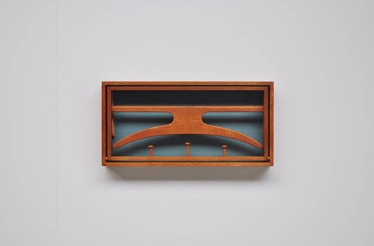 Very nice foldable coat rack designed by Adam Hoff & Poul Ostergaard for Virum møbelsnedkeri, Denmark 1960.This solid teak coat rack has a blue back and can be folded. The valet hook is attached with leather straps. The coat rack is signed 2 times