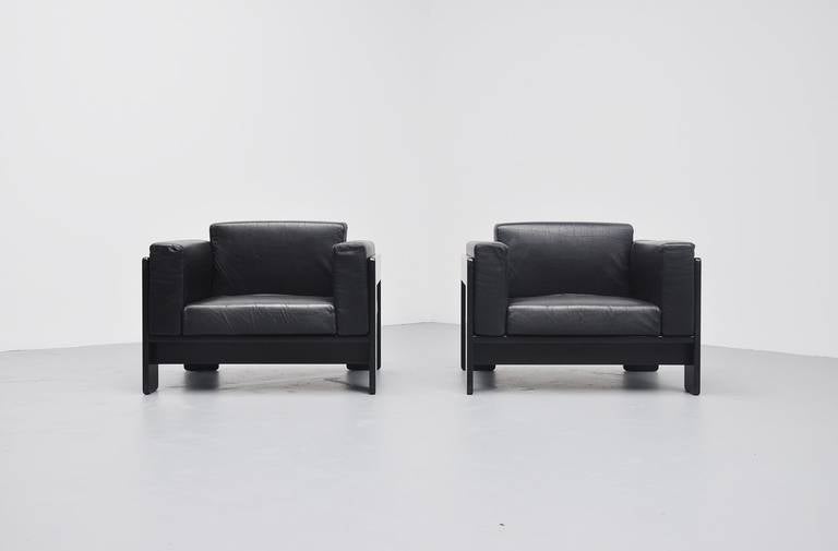 Very nice pair of club chairs model Bastiano designed by Afra & Tobia Scarpa for Gavina, Italy 1968. These chairs have a black lacquered wooden frame and black leather upholstery. The chairs are in good condition, the leather has a nice patina from