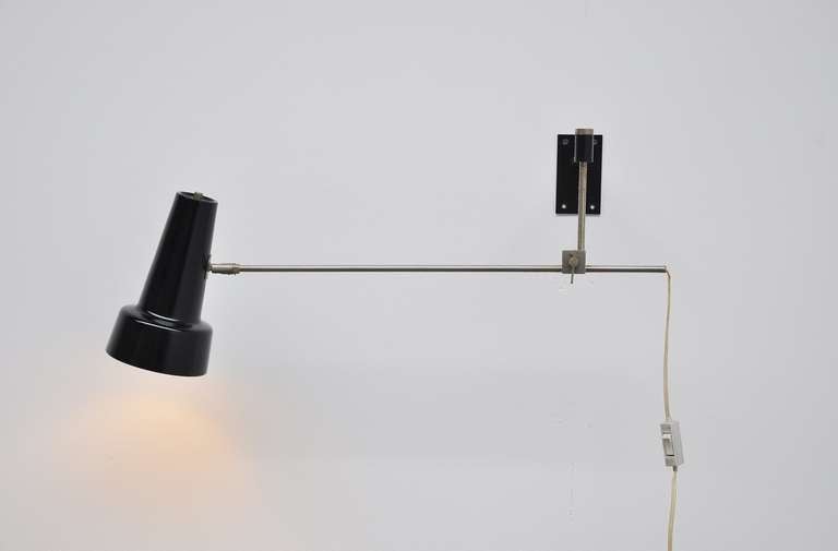 Very nice adjustable swing arm wall lamp by Dutch designer. Very nice nickel arm and black details.