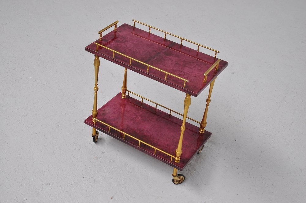 Two tier purple goat skin covered serving cart, with brass gallery edge and handles, carved arced pull handles and wheel posts, This is designed by Aldo Tura for Tura Milano ca 1960. Cart is in splendid condition.