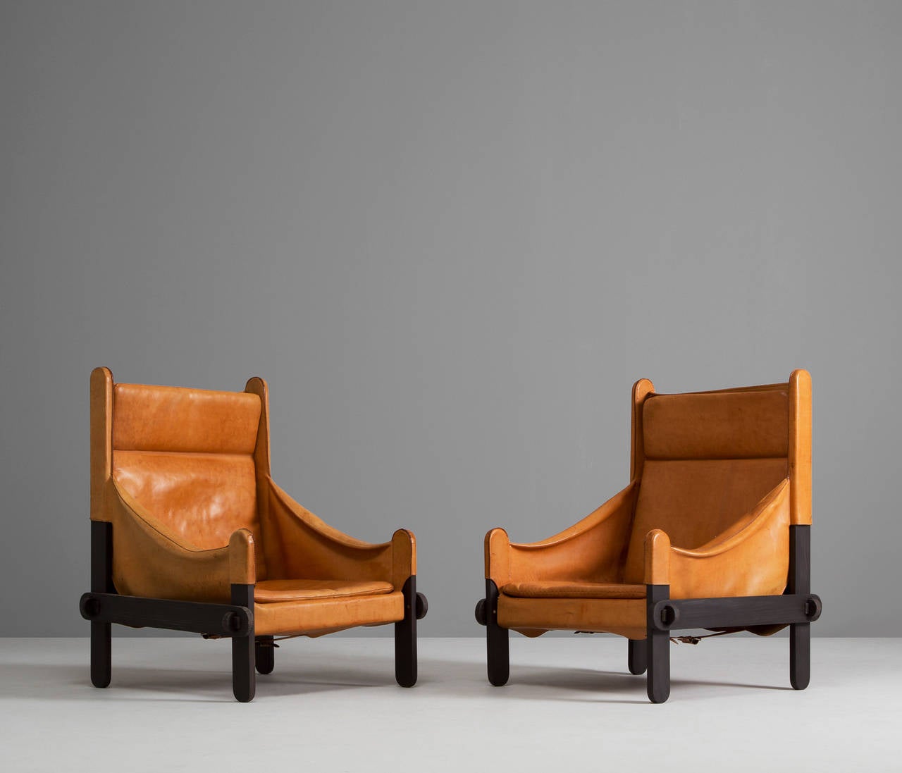 Armchairs, leather, wood, France, 1950s. 

These lounge chairs holds a solid crafted frame with decent wood details/joints.
The frame is 'covered' with nice thick leather with a nice patina. The leather is still in very good condition but have