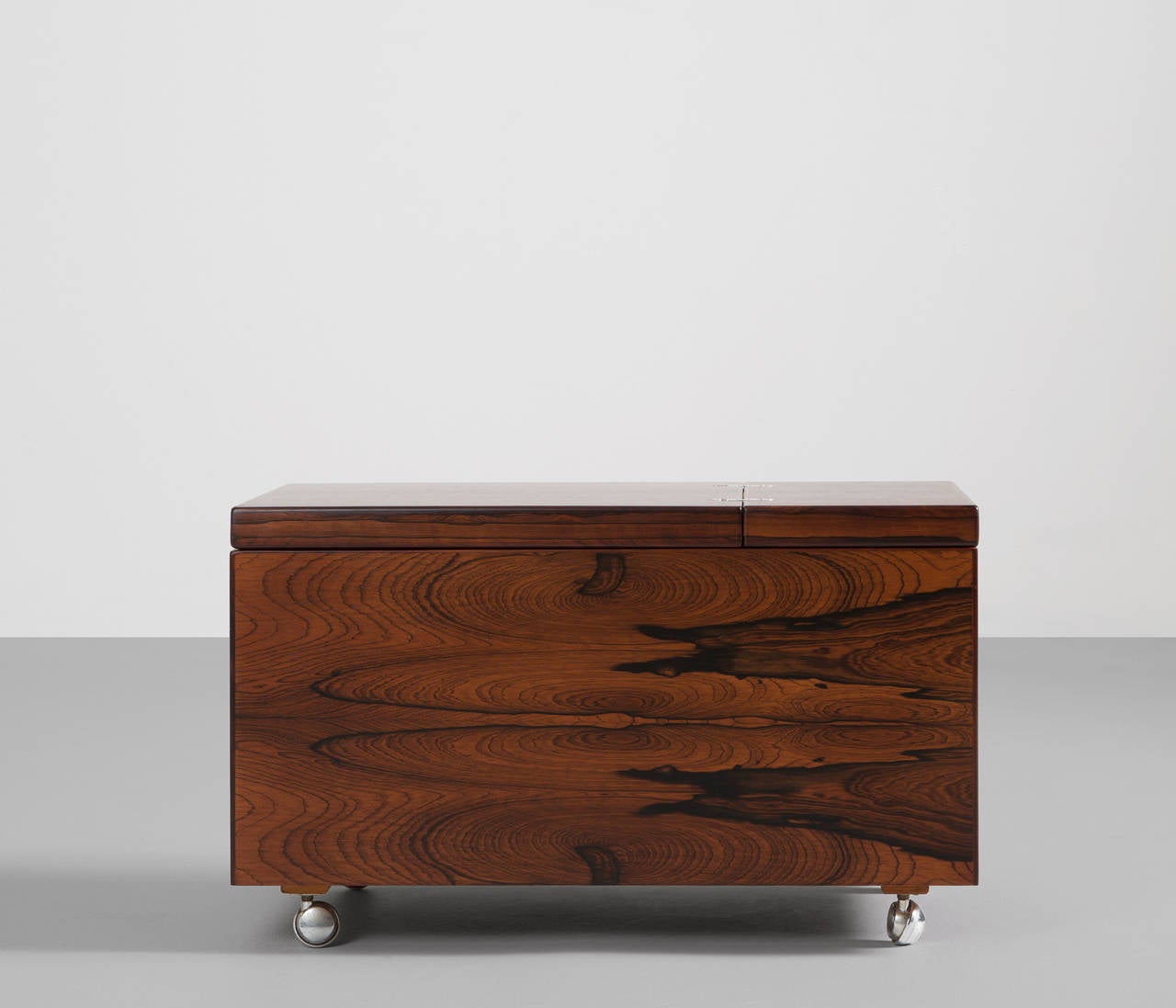 Luxurious mobile liquor bar cabinet made of Brazilian rosewood.
The top of the bar is easy to fold open due the elegant and well designed chrome hinges with also creates a very nice contrast.

When folded open, the partly red covered top serves