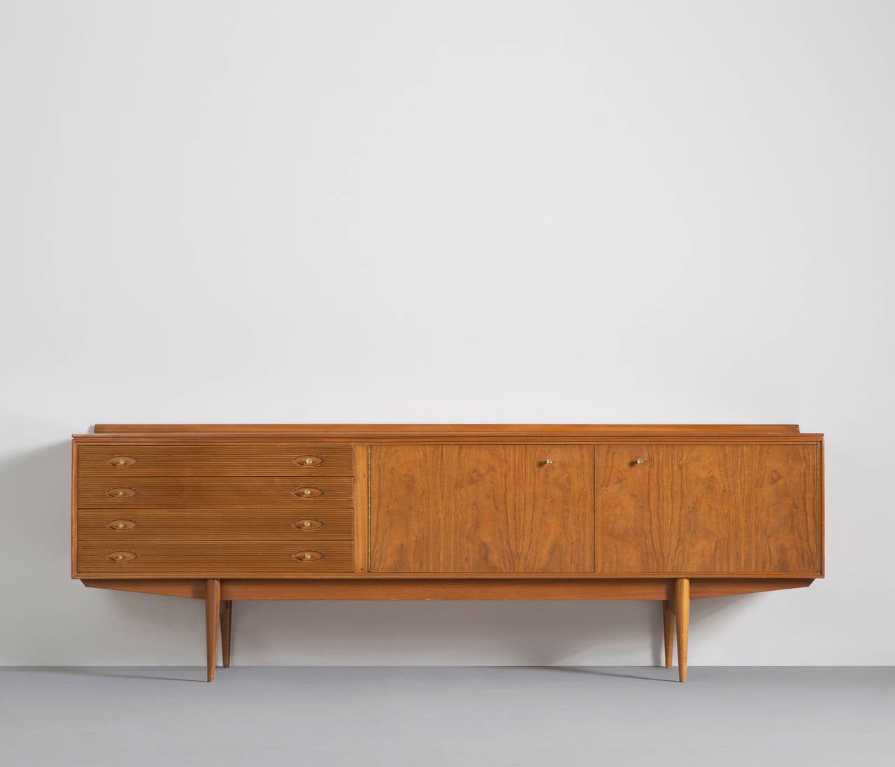 A rare sideboard designed by Robert Heritage.

This sideboard is equiped with a drawer section with 4 drawers and a large storage unit. The drawers are detailed with ridged fronts and brass handles based on tapered legs.

Designer Robert