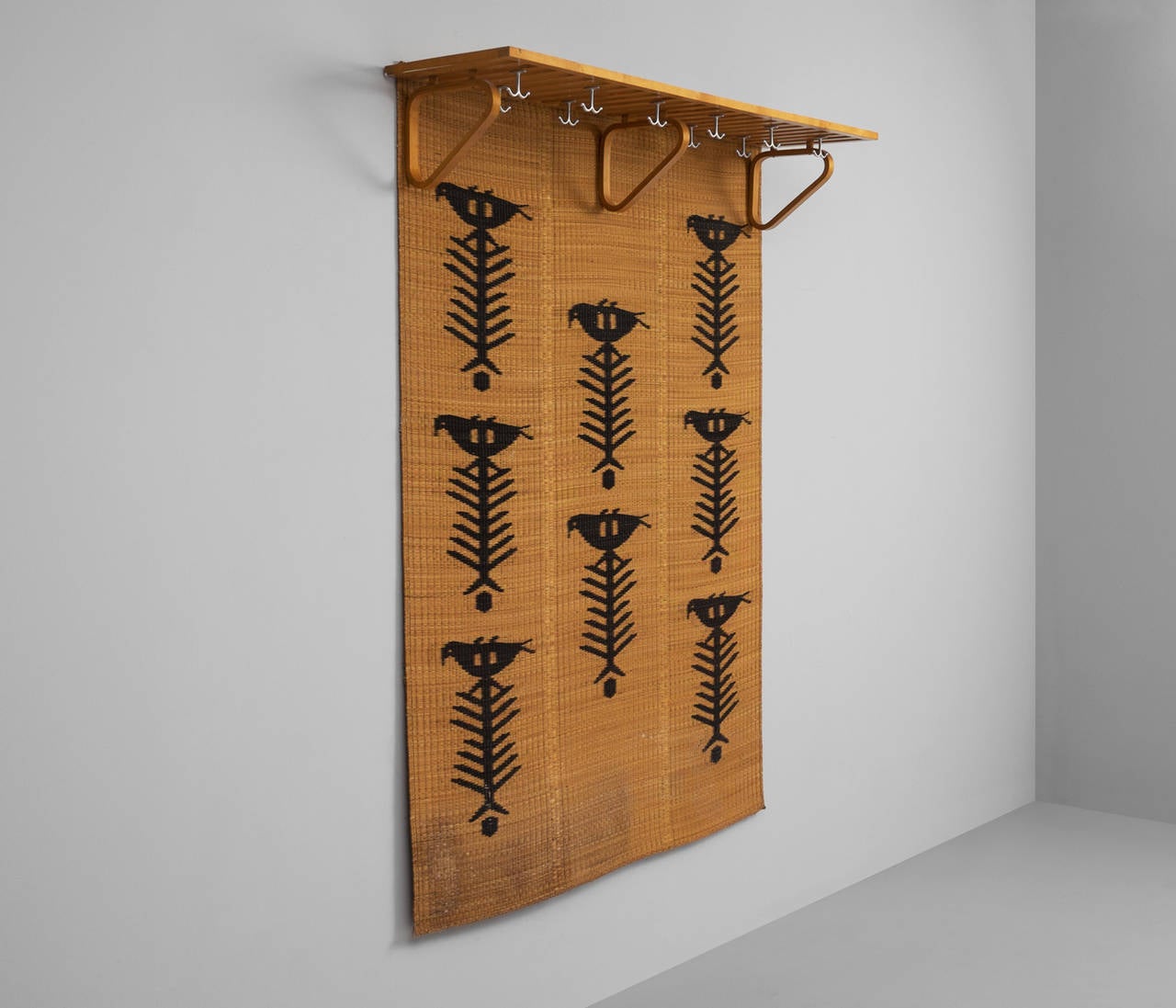 Coatrack designed by Alvar Aalto in beechwood and plywood with accompanying rattan wall decoration with graphic print. The combination is very unusual. The coatrack originate from the 1960s and is manufactured by Artek.

The ten metal hooks are