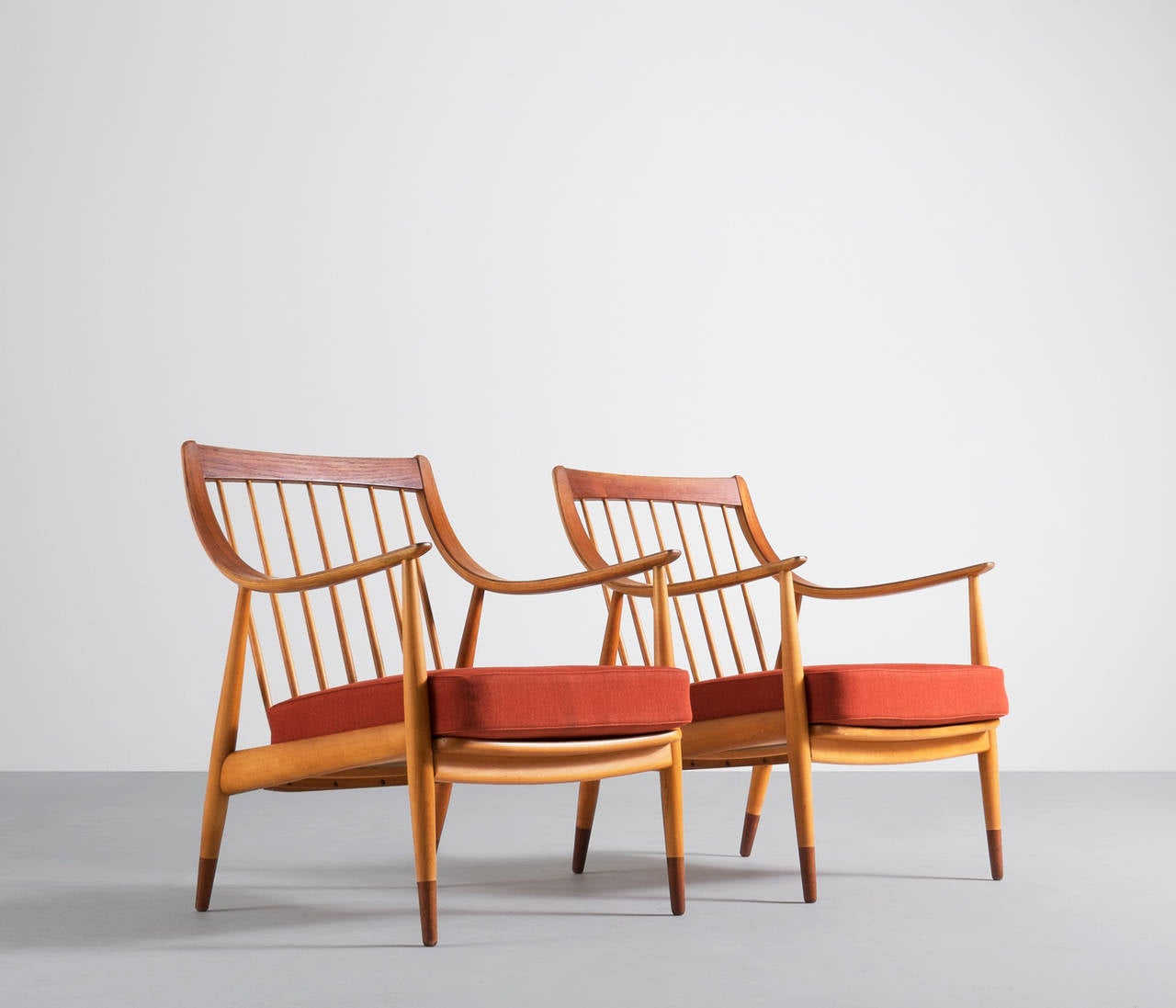 Beautiful sculptural matching pair of armchairs designed by Danish designer duo Peter Hvidt & Orla Mølgaard Nielsen.

The design complements the human form perfectly, providing a very comfortable chair and seat. A beautifully detailing on the back