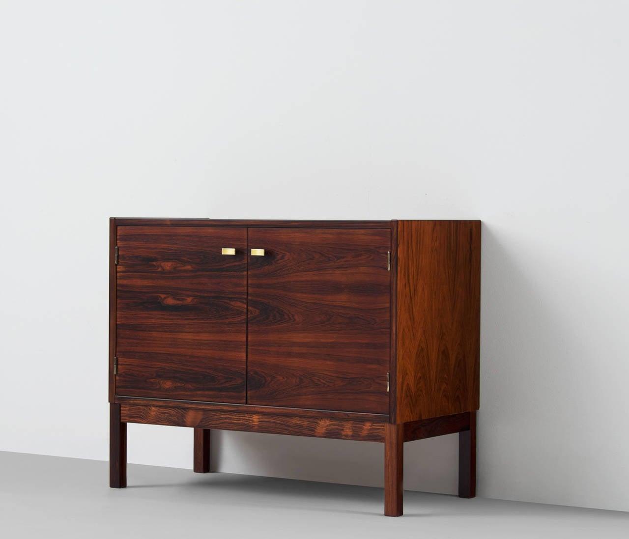 Wonderful designed compact rosewood console or sideboard. 

This highly refined small cabinet has some beautiful brass details and is very well manufactured. Excellent combination of shapes and materials.
