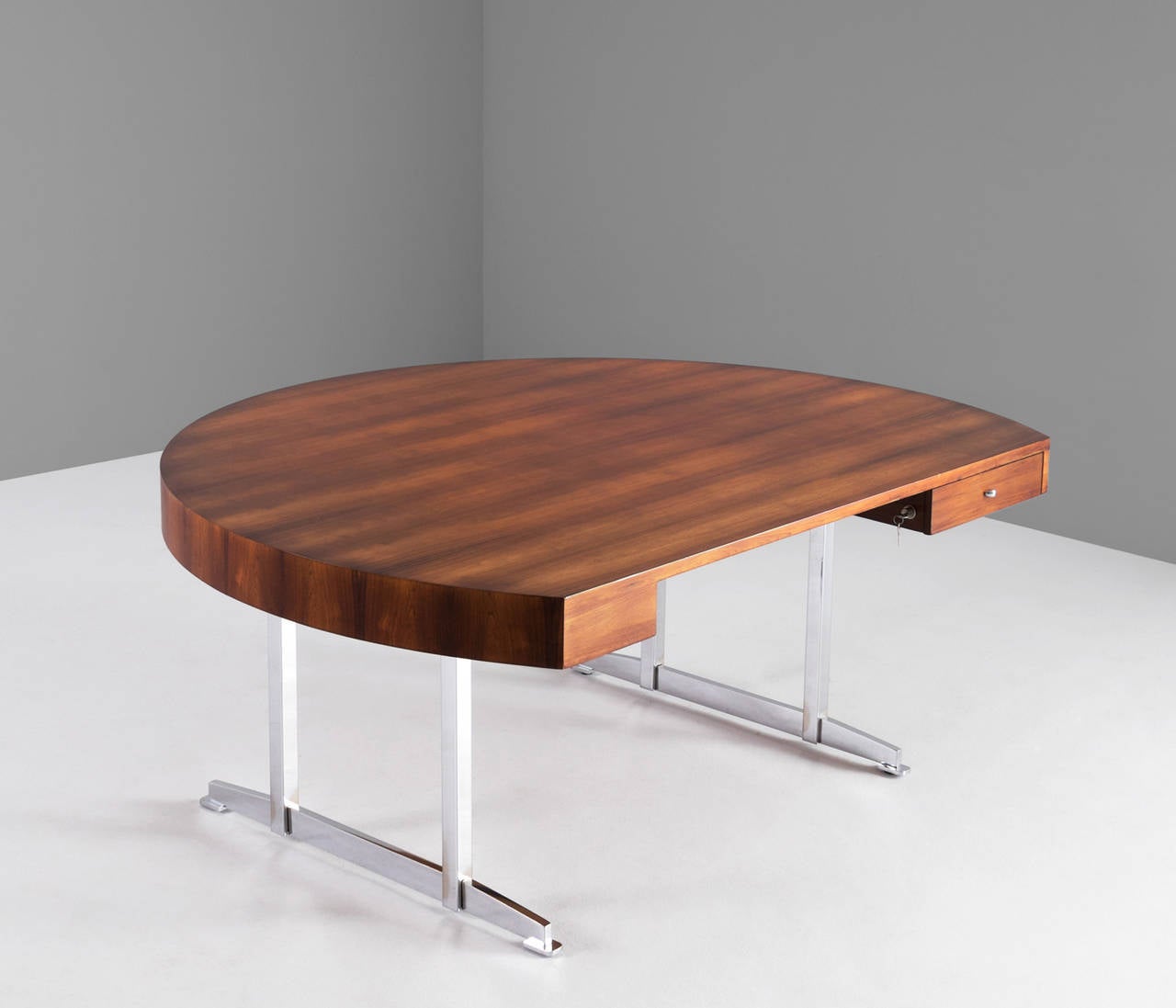 Extremely rare rounded shaped writing desk.

This high quality desk is equipped with one drawer on the right side. The large rounded rosewood desktop is supported by two chromed metal legs, which creates an open look.

Worldwide shipping