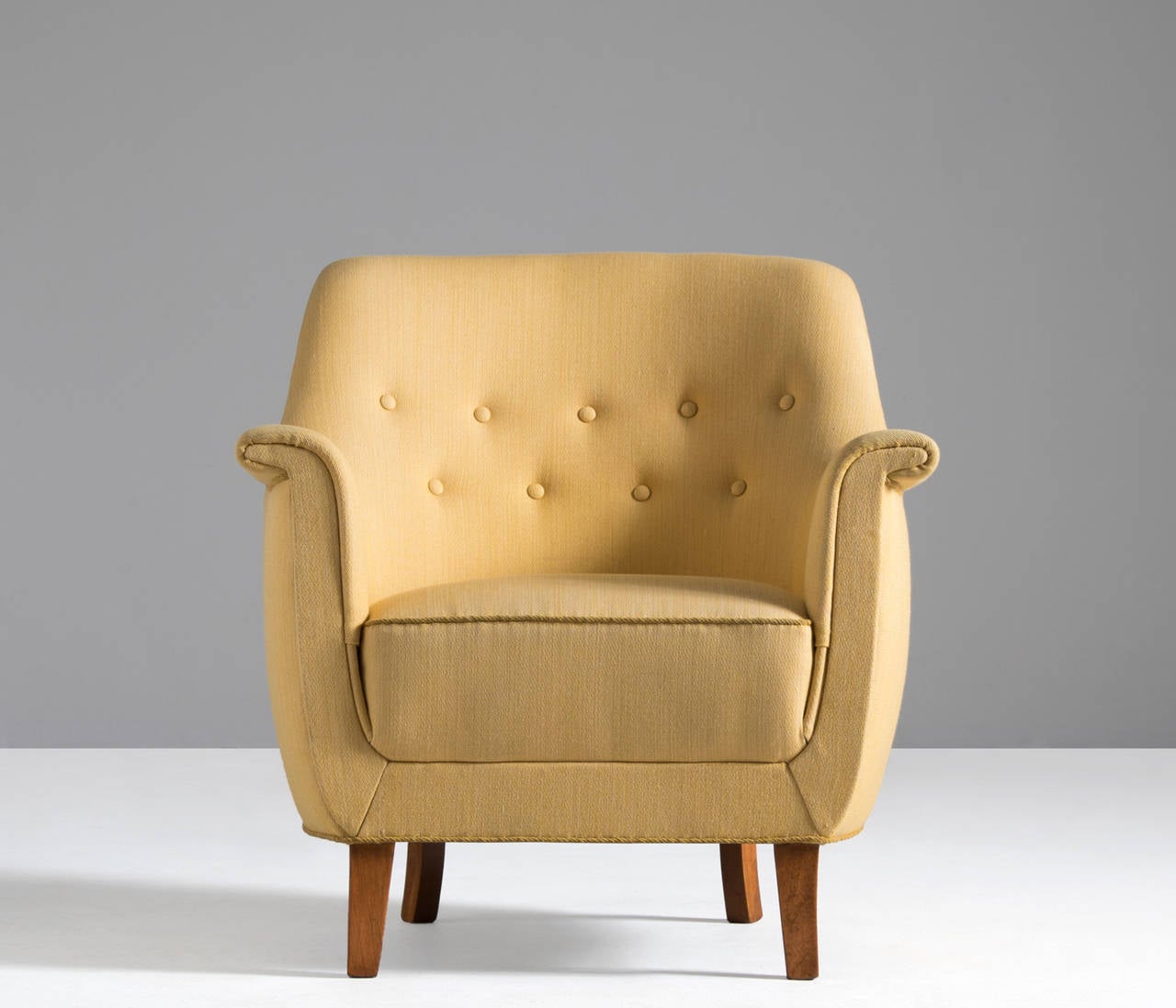 Danish elegant easy chair. The beautifully solid slightly tapered legs compliments the design of the seat perfectly. 

This easy chair is currently covered in original yellow upholstery. Re-upholstery is optional. Please ask our specialist for the