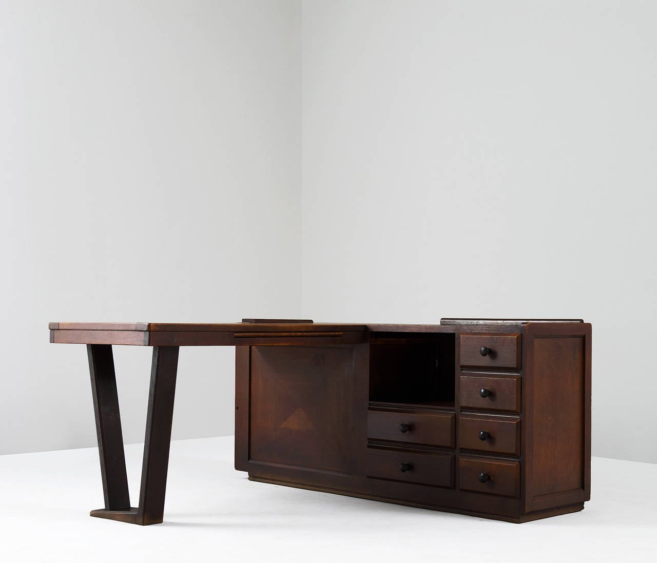 Dark stained oak desk by Guillerme et Chambron, France, 1950s.

This L-shaped desk has a large work surface and a return with plenty of storage facilities such a several drawers. The desk shows some highly crafted details and has an overall