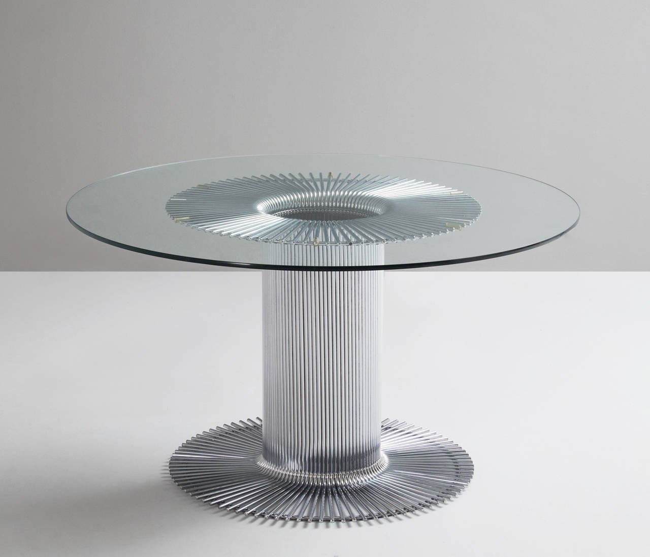 Center table, in chromed metal and glass, Italy 1960s. 

Pedestal dining table with a sculptural tubular chrome base and clear glass 
top. Designed in Italy. Distinguished basic design of the central base, with a beautiful visual effect due to the