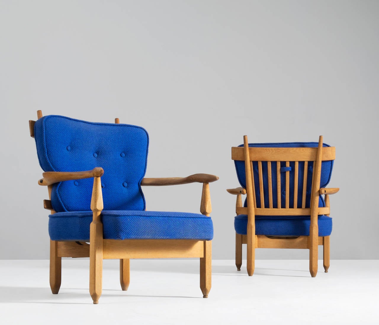 Lounge chairs oak, blue upholstery, oak, by Guillerme et Chambron, France, 1960s. 

Guillerme and Chambron are known for their high quality solid oak furniture, of which these two are another great example. These chairs have an interesting,