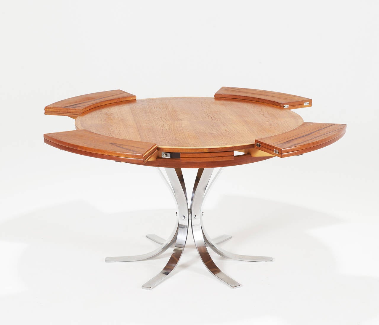 Round extend-able pedestal table by Dyrlund, Denmark, 1960s.

This rare to find table has a very well designed chrome base, six star model, finished with a teak top.
The top has the ability to extend in diameter. Four fold-able leaves are hidden