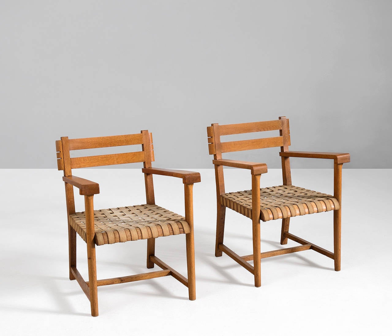 Set of armchairs, in oak and canvas, France 1940s. 

Sculptural pair of late Art Deco easy chairs, with their original canvas upholstery. The oak frame is well-designed and featured really nice construction details. A very solid yet elegant