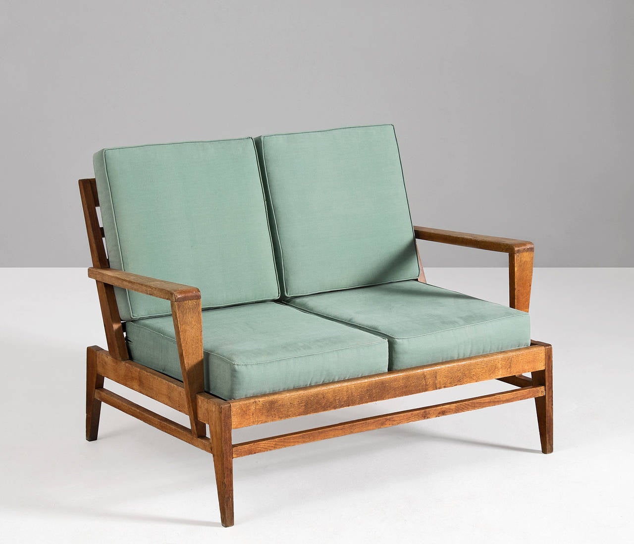 Rene Gabriel,  settee, in oak and fabric, by France 1950s. 

This sofa in oak is known for its solid yet elegant design focused on form and striking appeal. Currently upholstered in original light green fabric, reupholstery is advised. This is