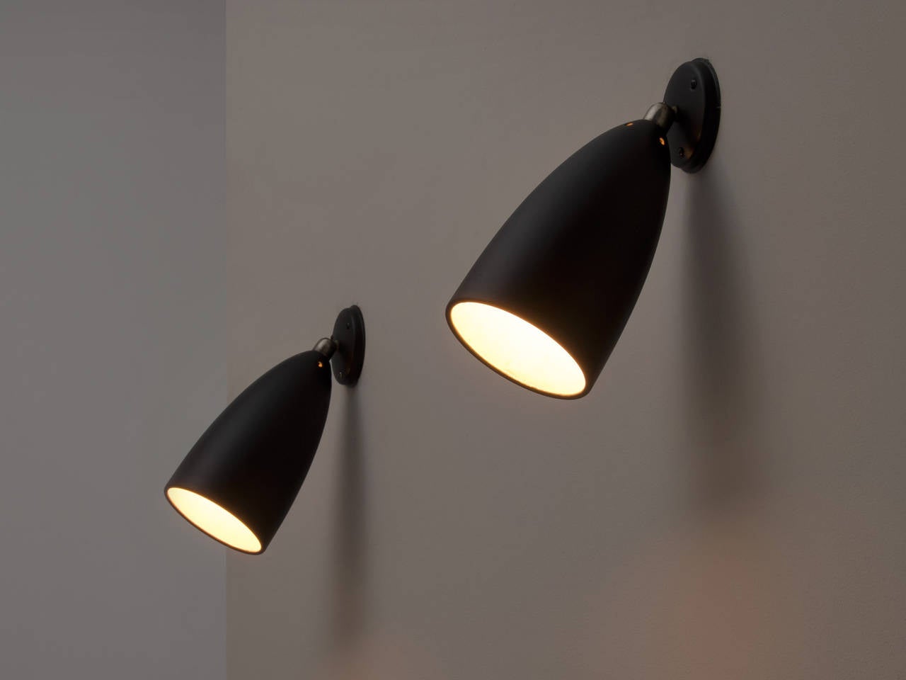 Wonderful set of two adjustable wall lights with black matte coated shade and base. The adjustable part is made of brass.

Can be used as down lighter and uplighter and the lights are fully adjustable. 
Very versatile and functional to use