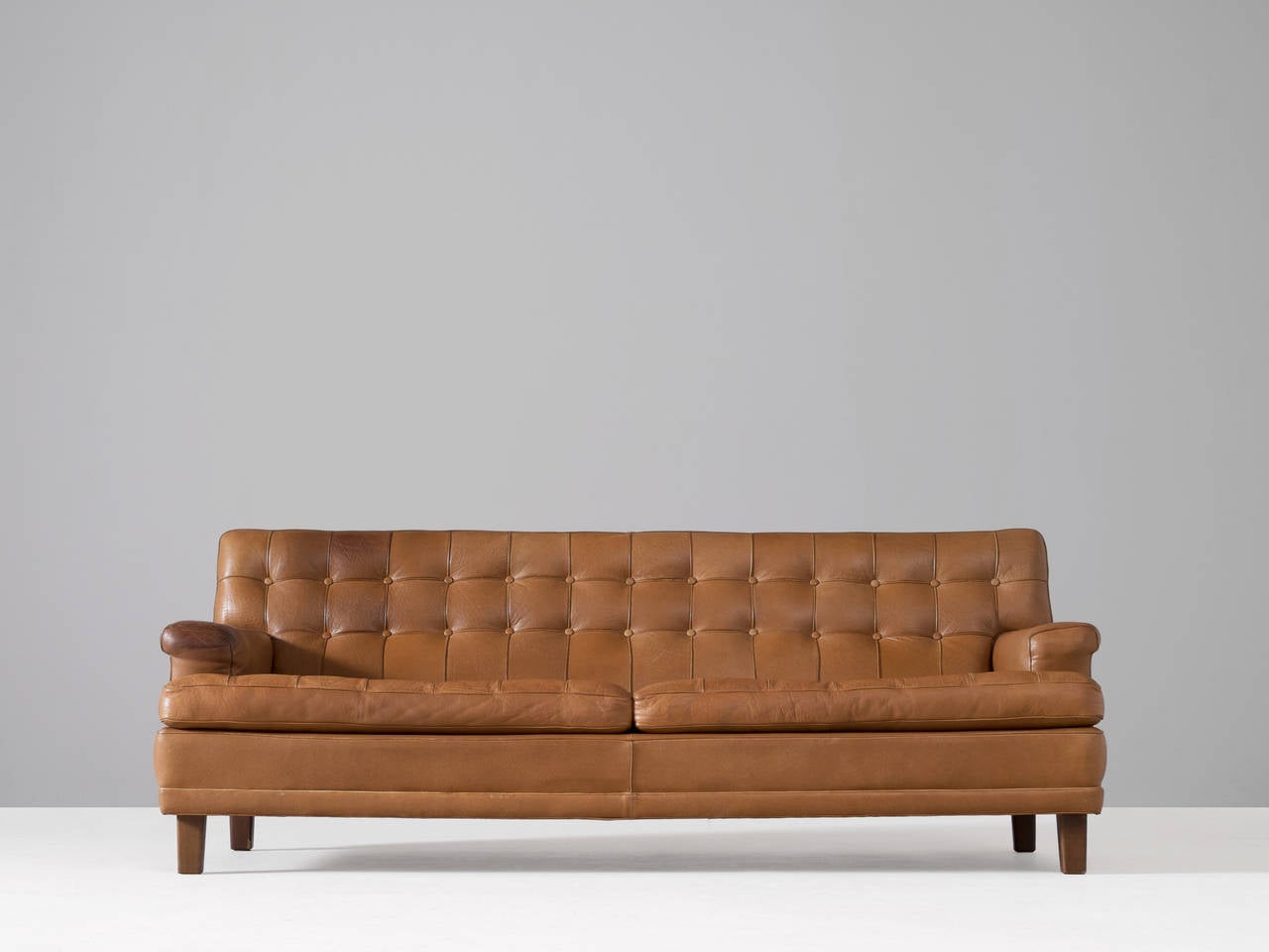 Sofa model 'Merkur', in leather and wood, by Arne Norell, Sweden, 1960s. 

This three-seat sofa is designed by Swedish designer Arne Norell. Wonderful proportioned and highly comfortable sofa. The tufted cushions with leather buttons and piping