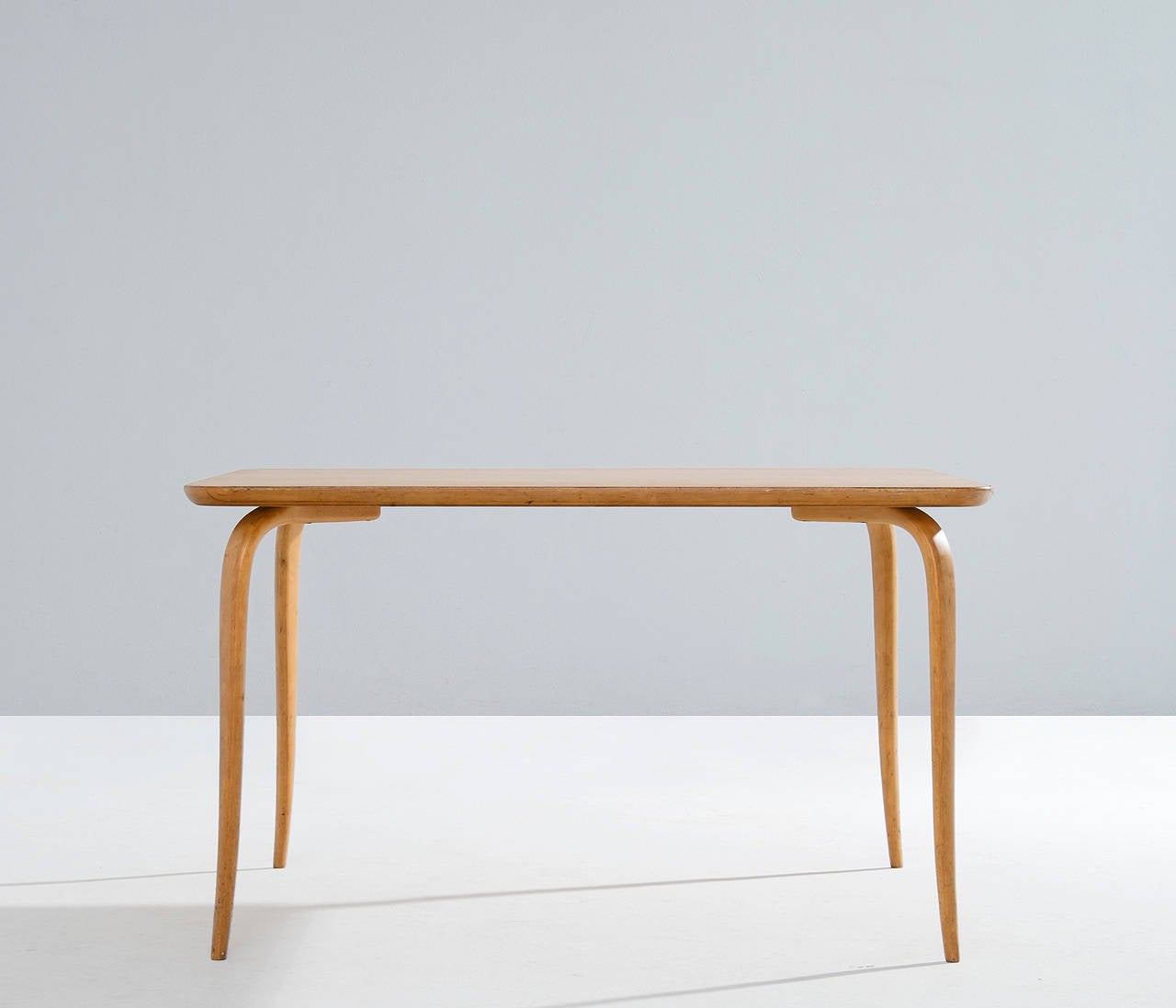 Very refined coffee table by Bruno Mathsson, Sweden, 1950s.

This Annika coffee table has birch plywood legs, which are fluently curved and tapered. These light legs are elegant and give this piece its unique appearance.

The burl wood veneer