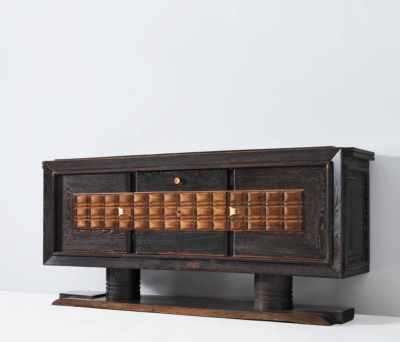 Sideboard in oak and copper by Charles Dudouyt, France, 1930s.

This French Art Deco oak credenza originates from the 1930s and is designed by the French decorator Charles Dudouyt. The door panels show an interesting pattern of solid natural wooden